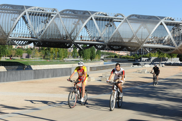Radfahrer vor der modernen Brücke Arganzuela in Madrid
