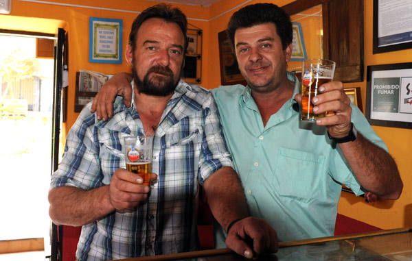 Männer prosten dem Fotografen in einer spanischen Bar zu