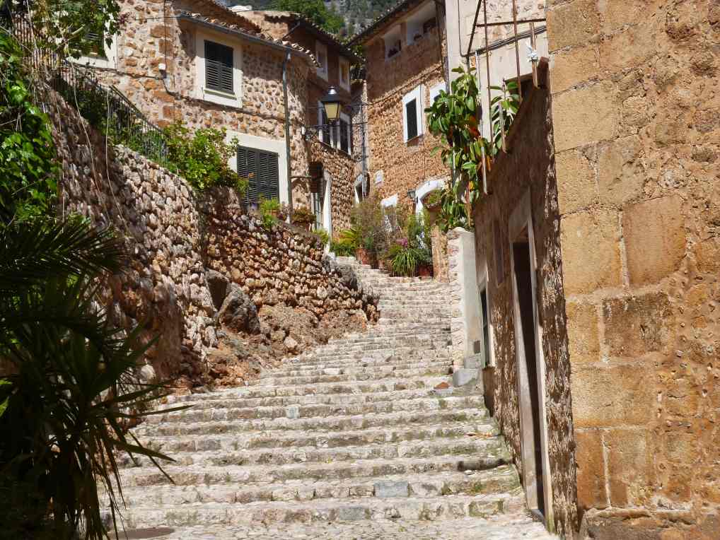 Mediterrane Steinh&auml;user mit Gr&uuml;npflanzen entlang eines alten Treppenweges