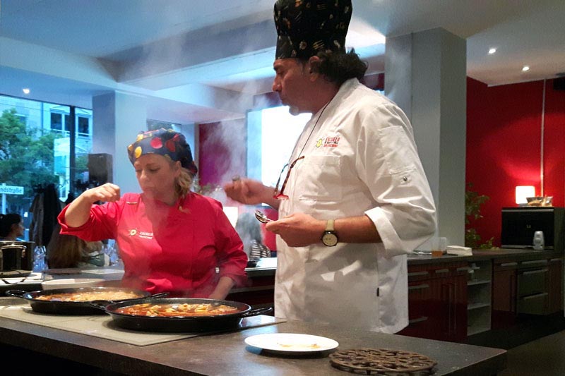 Zwei Köche bereiten Paella Velanciana zu