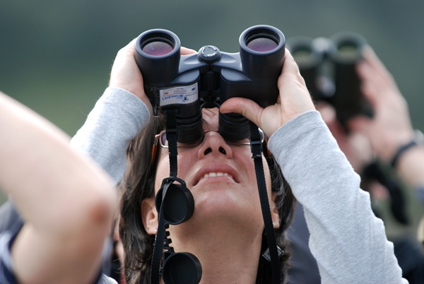 Eine Vogelbeobachterin mit einem Fernglas